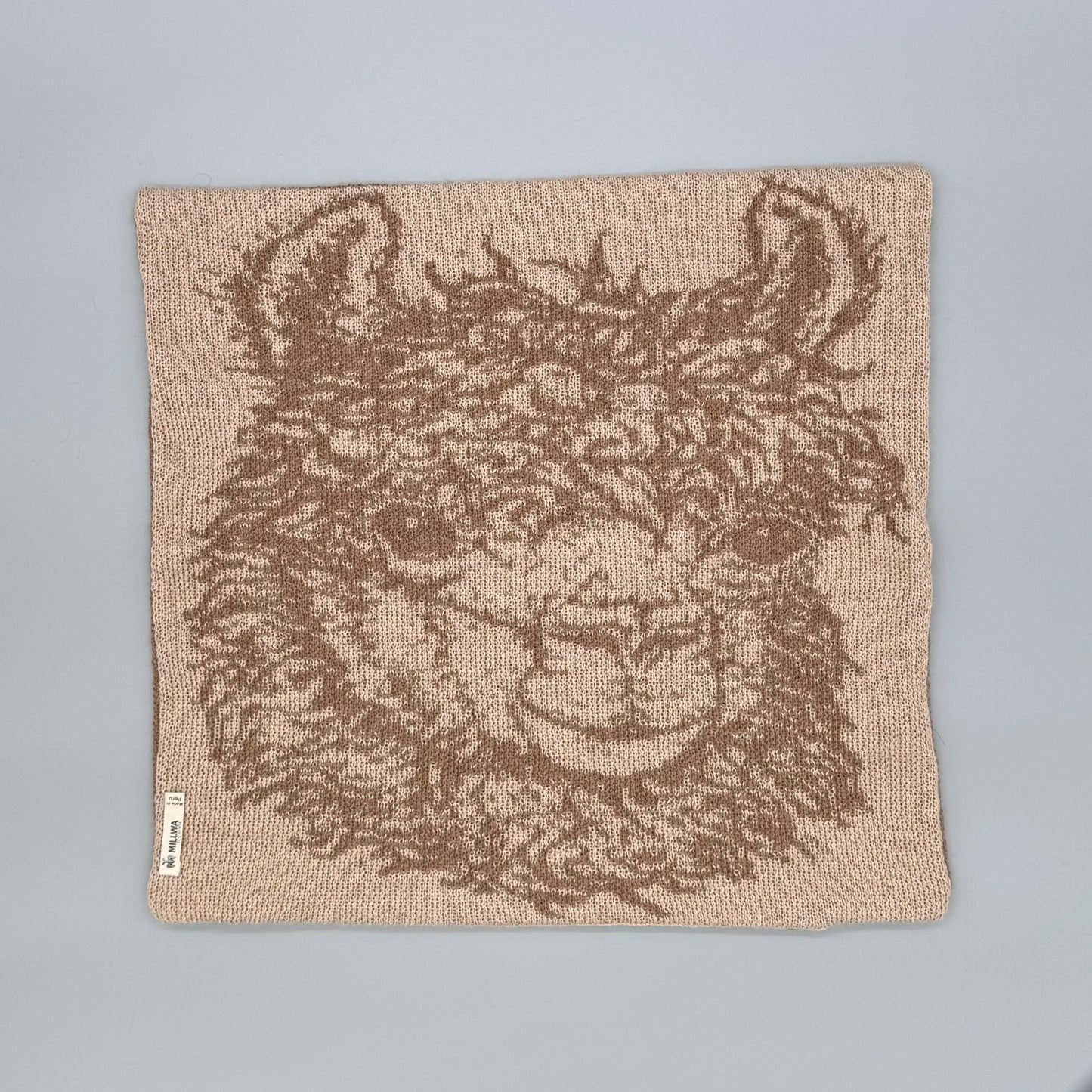 Alpakawolle Kissen mit handgestricktem Alpaka-Motiv in sanften Braun- und Grautönen, perfekt für jeden Wohnraum.