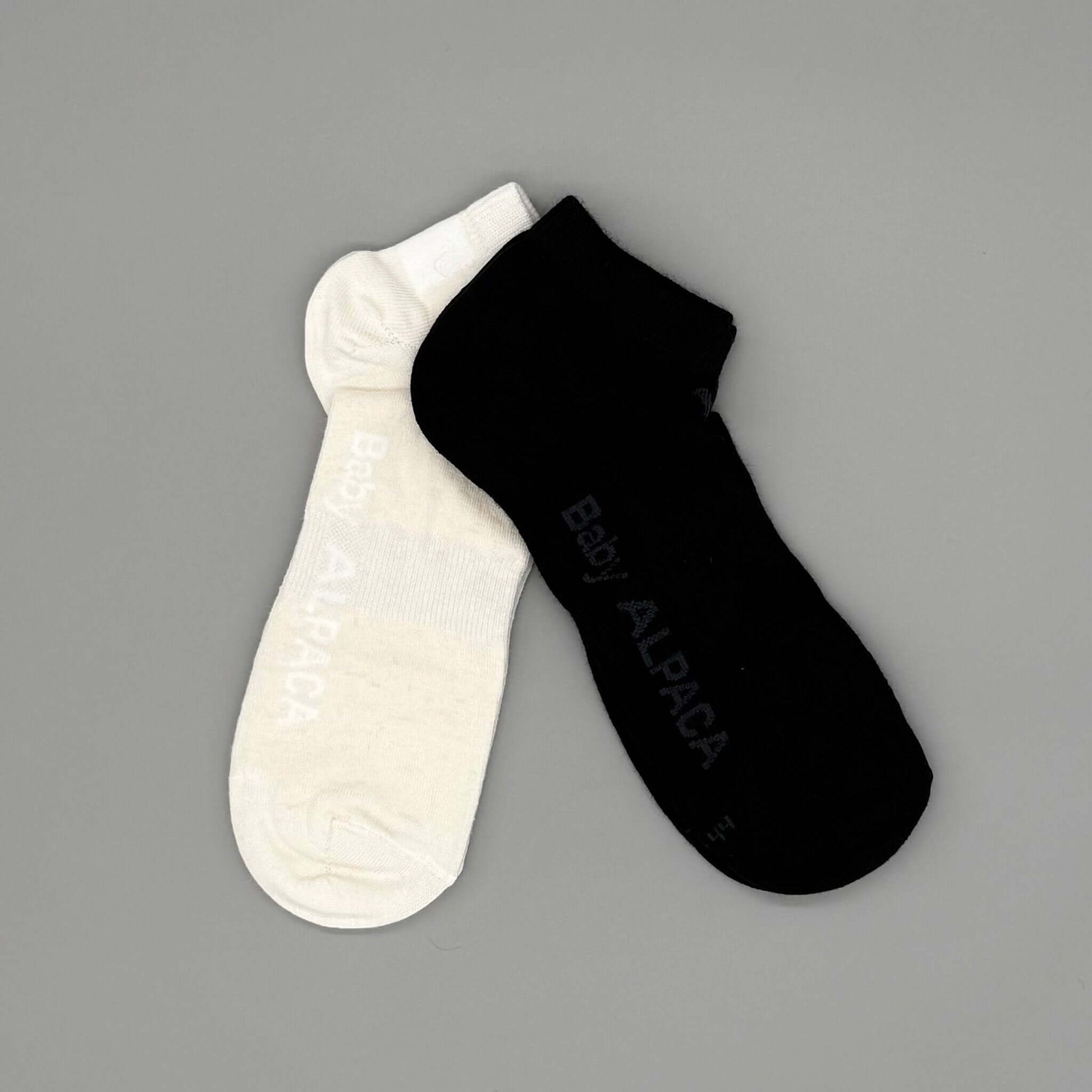 Alpakasocken aus 70% Baby Alpakawolle in Weiß und Schwarz, ideal für Frühling und Sommer.
