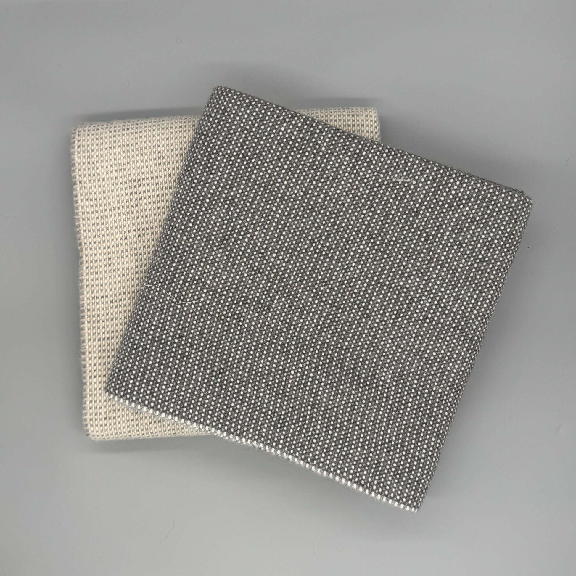 Moderne 130 x 180 cm Sofadecke Baby Alpaka Wolle in Beige und Grau auf grauem Hintergrund.