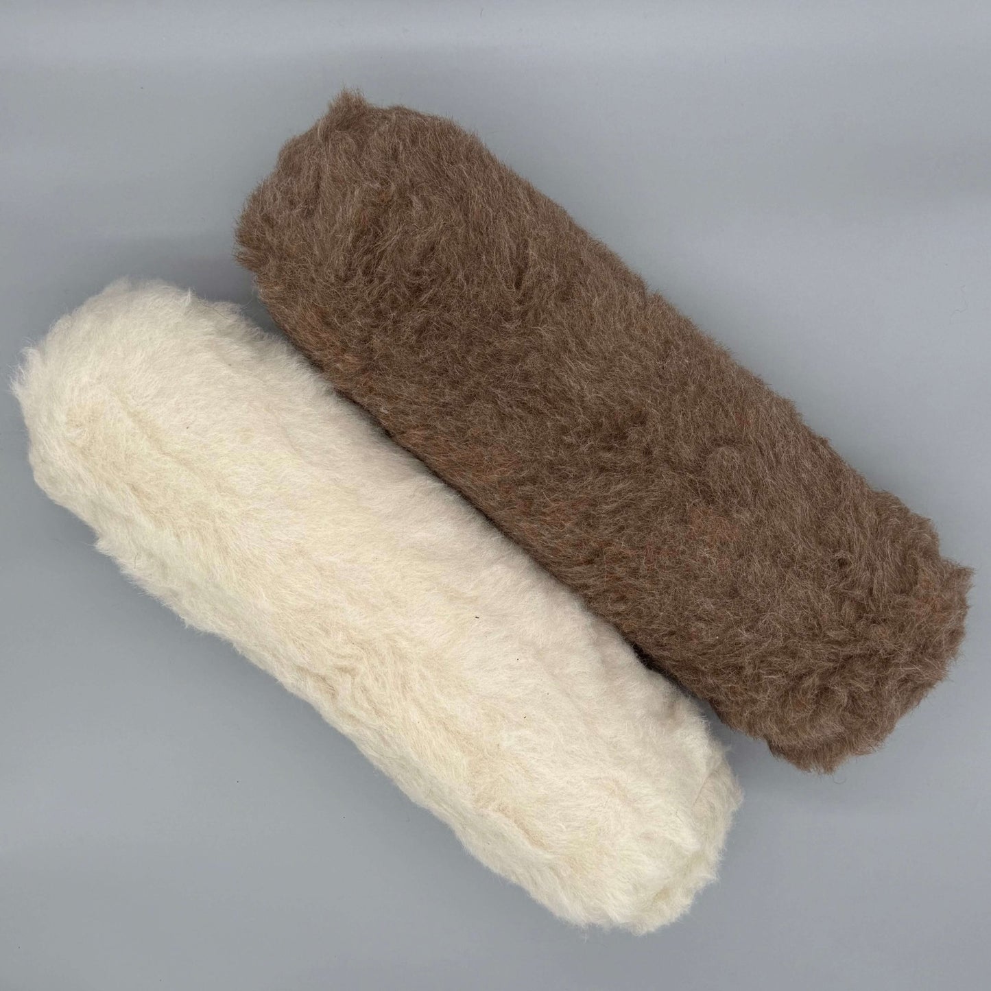 Nackenrolle aus Alpaka Wolle in Braun und Weiß, extra langes flauschiges Kopf Kissen mit Alpakaflor.