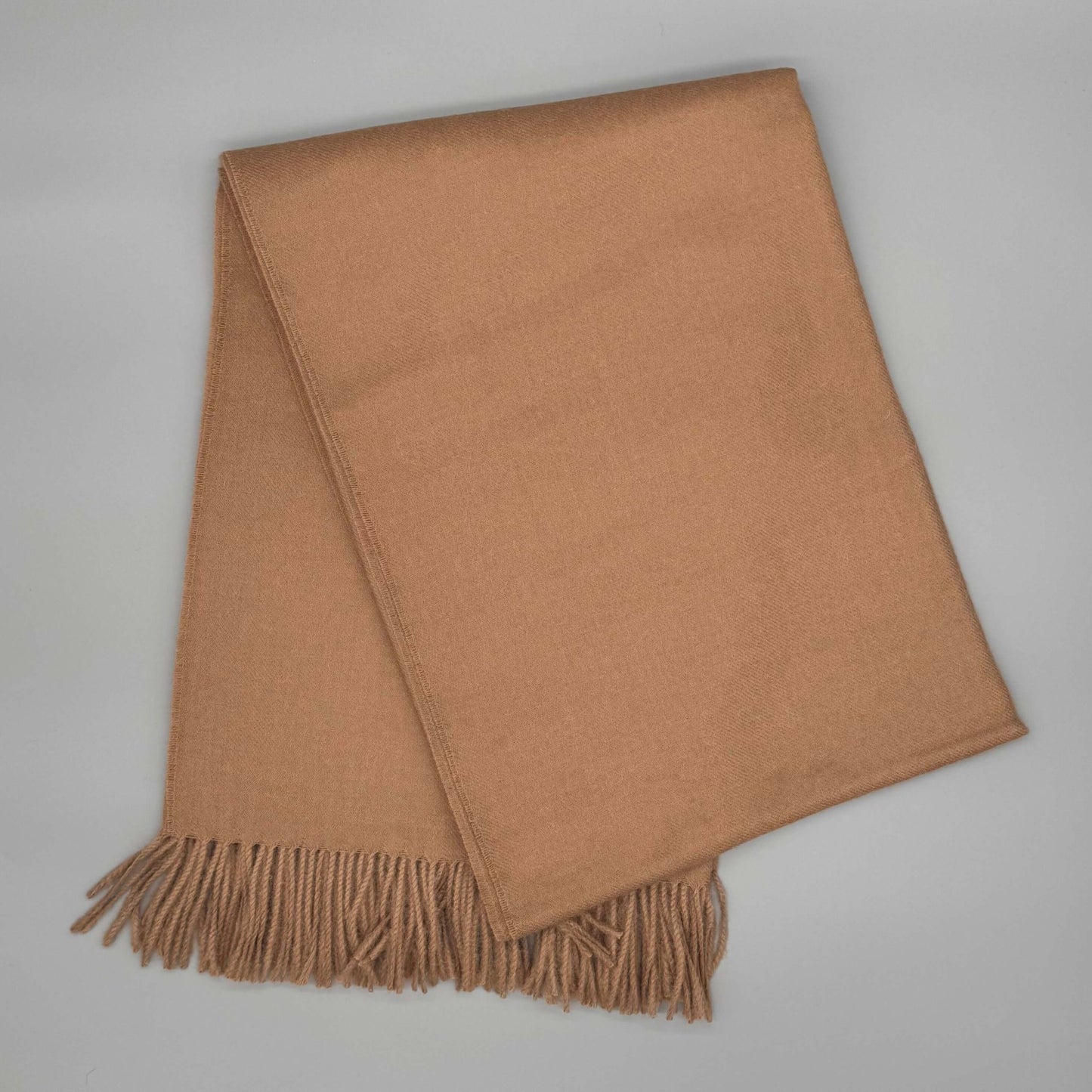 Kuschelige Alpaka Couchdecke 135x180cm in Beige mit Fransen, aus 100% Baby-Alpakawolle für Wärme und Eleganz.