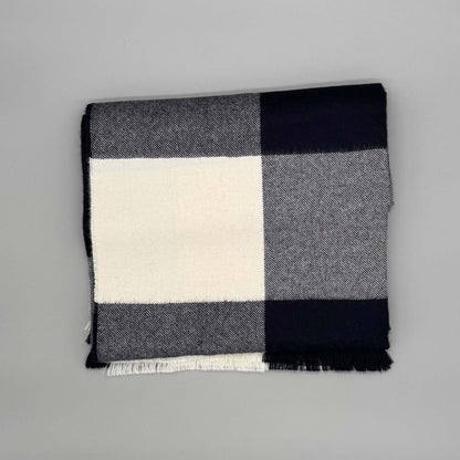 Flauschige Decke 130x180 cm aus 100% Babyalpakawolle im Karomuster (Blau, Grau) auf grauem Hintergrund.