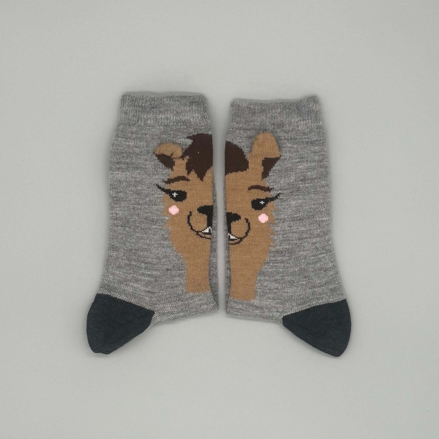 Niedliche Alpakasocken kaufen mit Alpaka-Motiv und 3D-Öhrchen in Grau, aus 41 % Alpakawolle.