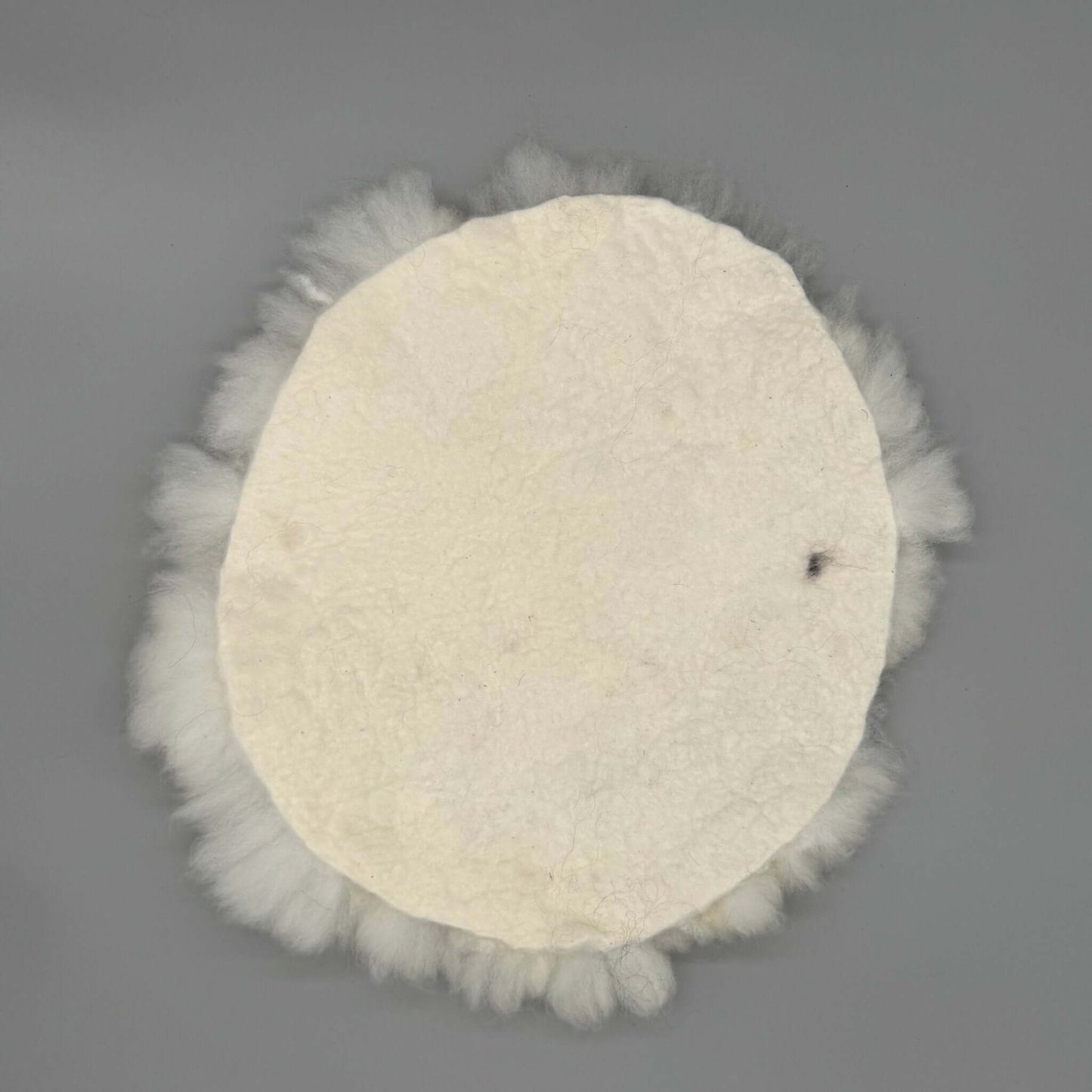 Alpaka Sitzkissen aus weißer Alpakawolle, handgefilzt und rund, Durchmesser ca. 40 cm.