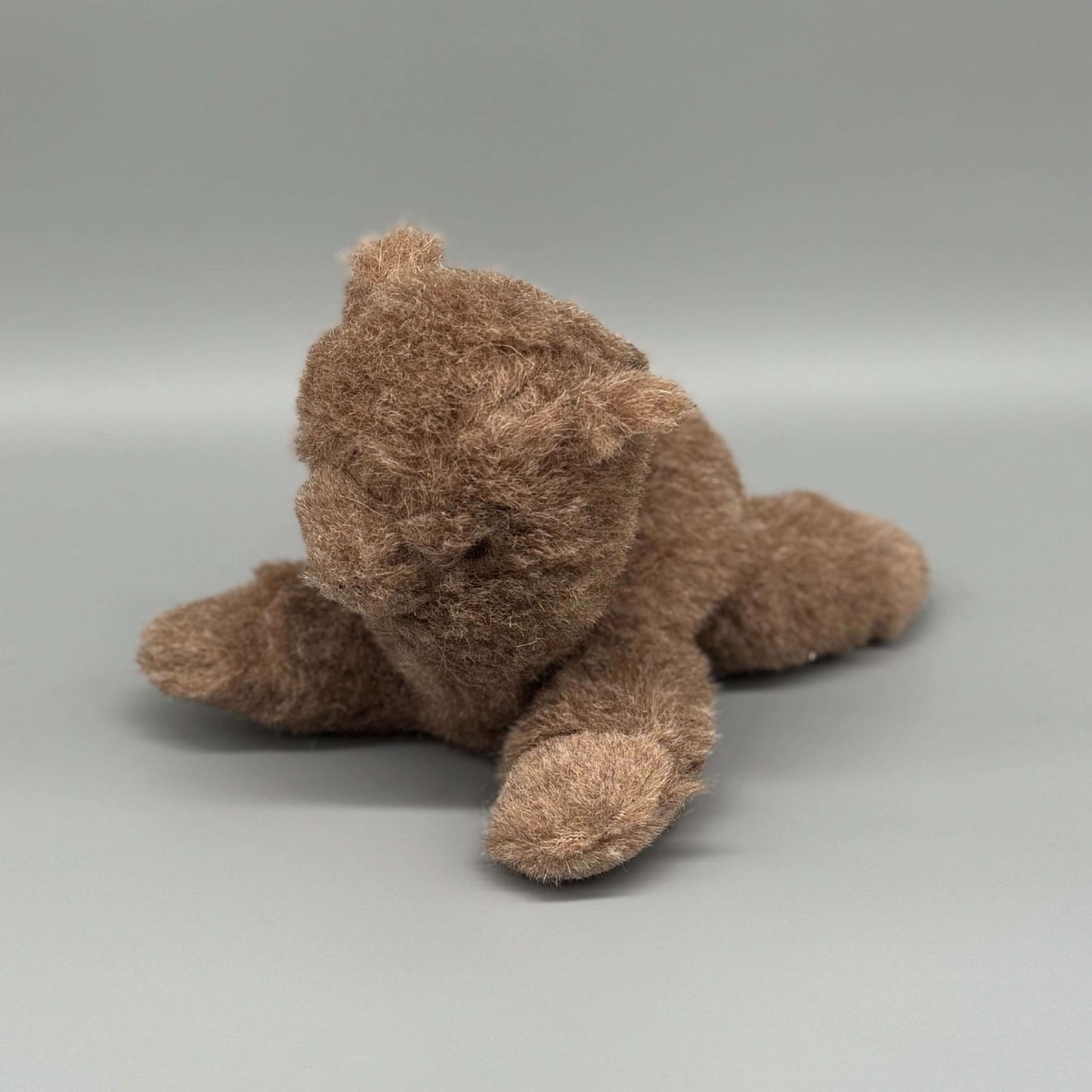 Alpaka Kuscheltier handgemacht aus 100 % Alpakawolle, sitzend in Braun, ideal zum Kuscheln und Spielen.