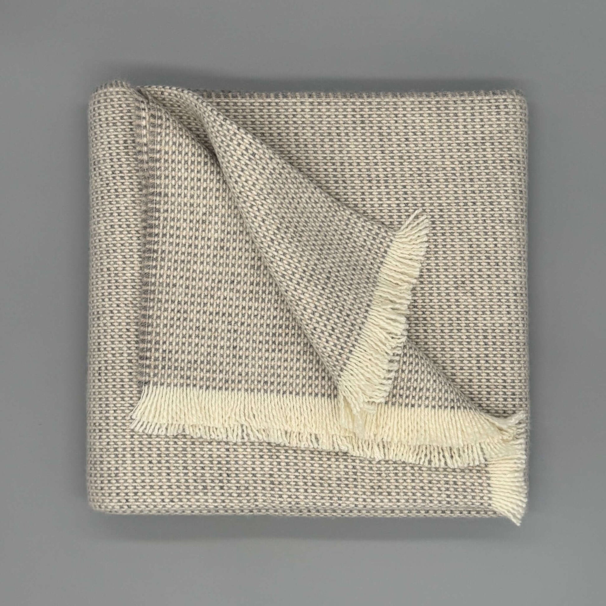 Beige und graue Sofadecke Baby Alpaka Wolle mit feiner Webstruktur und eleganten Fransen, 130 x 180 cm.