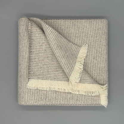 Beige und graue Sofadecke Baby Alpaka Wolle mit feiner Webstruktur und eleganten Fransen, 130 x 180 cm.