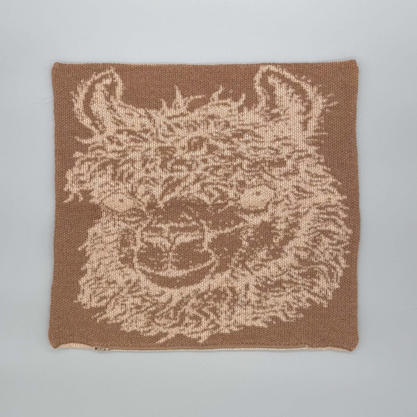 Alpakawolle Kissen mit handgestricktem Alpaka-Motiv in Braun und Beige, ideal für Zuhause.