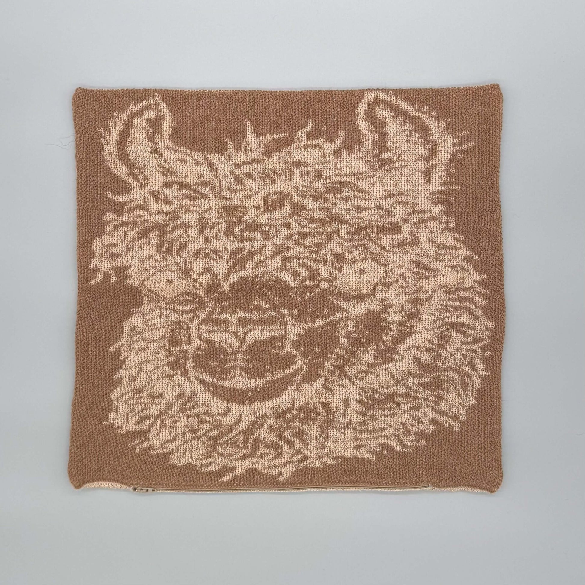 Alpakawolle Kissen mit handgestricktem Alpaka-Motiv in Braun und Beige, ideal für Zuhause.